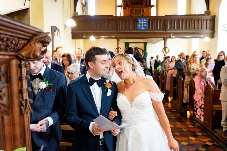 Bride and groom smiling during a church wedding ceremony